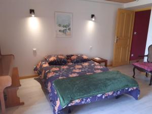 une chambre avec un lit avec une couette verte dans l'établissement Coeur de Village du Haut-Jura, à Les Bouchoux