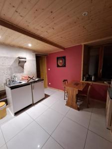 une cuisine avec un plafond en bois et une table dans l'établissement Coeur de Village du Haut-Jura, à Les Bouchoux 37 autres photos