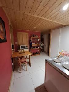 une cuisine avec une table et une salle à manger dans l'établissement Coeur de Village du Haut-Jura, à Les Bouchoux