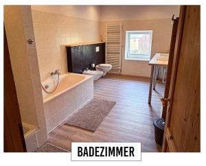 a bathroom with two toilets and a bath tub at Landhaus in Springe
