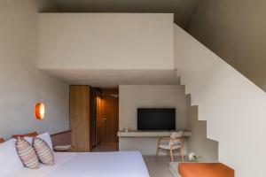 a bedroom with a bed and a tv and a staircase at La Suera San Pantaleo in San Pantaleo