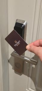 una persona con una tarjeta en una manija de la puerta en Imaret Hotel, en Ganja