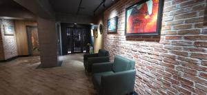 eine Lobby mit Stühlen und einer Backsteinmauer in der Unterkunft Imaret Hotel in Ganja