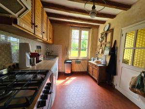 a kitchen with a stove and a counter top at Détente absolue et piscine chauffée 