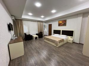 a hotel room with a bed and a living room at Baku Center inn NS in Baku