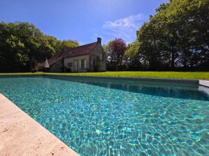 a swimming pool in front of a house at Détente absolue et piscine chauffée 