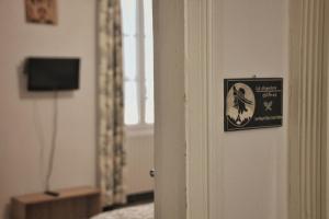 een bord op de deur van een kamer bij La Maison des Mousquetaires in Condom