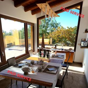 a dining room with two tables and a large window at Le Querce Dell'Etna B&B in Ragalna