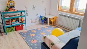 a childs room with a table and a couch at Loft Szczytna in Szczytna