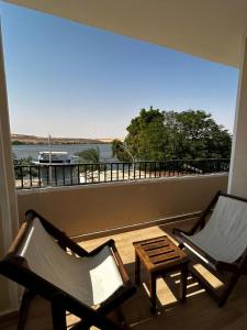 two chairs and a table on a balcony with a view at Golden Sun House II in Abu Simbel