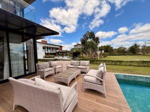 a patio with wicker chairs and a swimming pool at Águas da Serra in Bananeiras