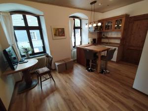 a kitchen with a desk and a table in a room at Ferienwohnung Sauerland Burgfenster in Bilstein +17 photos