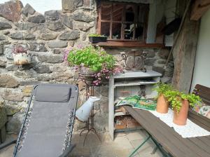 a table and a chair in front of a stone wall at Ferienwohnung Sauerland Burgfenster in Bilstein