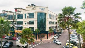 a large building with cars parked in a parking lot at Blenz Hotel in Serdang