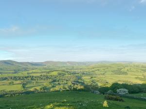 a view of a green field with mountains in the background at Gwenllian in Machynlleth