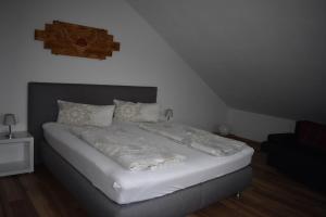 a bedroom with a bed with white sheets and pillows at Ferienwohnung Wiedergrün in Durbach