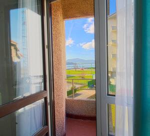 una puerta a un balcón con vistas a un edificio en Entre Playa y Puntal, en Somo