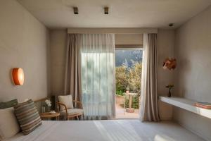a bedroom with a bed and a large window at La Suera San Pantaleo in San Pantaleo +76 photos