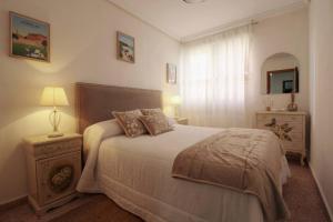 a bedroom with a bed and a table with a lamp at La Luz de La Concha in Suances