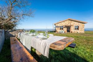 a table with plates and wine glasses on top of a field at Casona Alto Sarracin in Lloreda