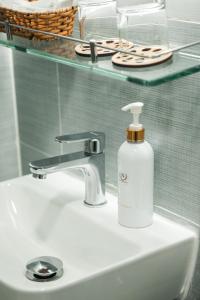 una botella de jabón blanco encima de un fregadero en Cashew Inn, en Ho Chi Minh
