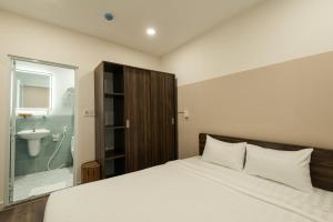 Un dormitorio con una cama y un baño con lavabo. en Cashew Inn, en Ho Chi Minh