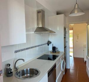 a white kitchen with a sink and a stove at Apartamento Aventuras in Comillas