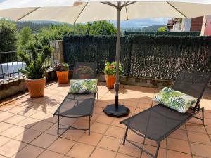 a patio with two chairs and an umbrella at Apartamento Aventuras in Comillas +39 photos