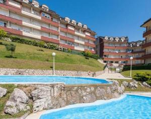 een zwembad voor een groot appartementencomplex bij Acacios en La Concha in Suances