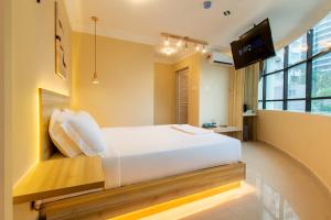 ein Schlafzimmer mit einem weißen Bett und einem Flachbildfernseher in der Unterkunft Blenz Hotel in Serdang + 37 Fotos