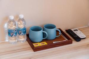 a tray with two cups and two bottles of water at Blenz Hotel in Serdang