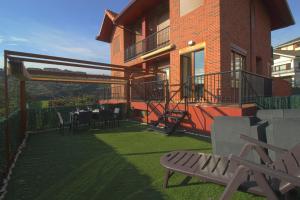 a house with a patio with a table and chairs at La Casa del Muelle in Suances