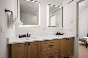 a bathroom with a sink and two mirrors at Lake & Laughter Unit 2 in Rockaway Beach +30 photos