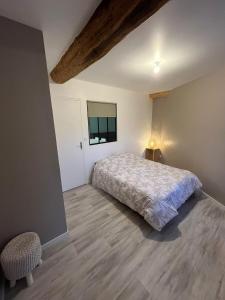 a bedroom with a bed and a table and a window at Appartement cosy rénové dans une ancienne longère in Chemilly-sur-Yonne