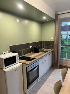a kitchen with a microwave and a stove top oven at Appartement cosy rénové dans une ancienne longère in Chemilly-sur-Yonne +1 photo