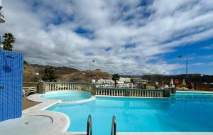 a large swimming pool with blue water at playa del cura apartment with terrace in Mogán