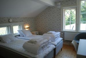 een slaapkamer met twee bedden met witte dekens erop bij Sofielund Vandrarhem & Camping in Sala