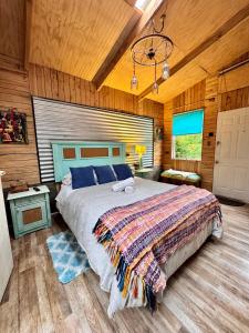 Un dormitorio con una cama grande en una habitación con paredes de madera. en Apartamento Hortensias del Lago, en Puerto Varas