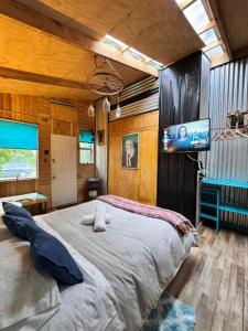 Un dormitorio con una cama grande y un televisor de pantalla plana. en Apartamento Hortensias del Lago, en Puerto Varas