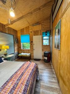 Un dormitorio con una cama en una habitación de madera. en Apartamento Hortensias del Lago, en Puerto Varas 15 fotos más