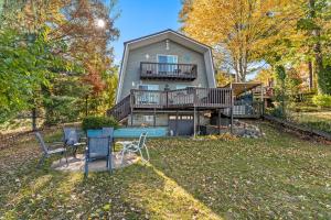 a house with a deck and chairs in the yard at Crocker Lake Escape in Twin Lake