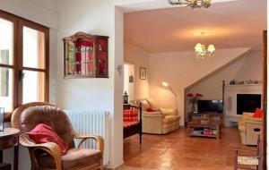a living room with a staircase and a living room with chairs at Villa spacieuse avec piscine à Saint-Michel-d'Euzet in Saint-Michel-d'Euzet
