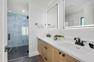 a white bathroom with a sink and a shower at Lake & Laughter Unit 1 in Rockaway Beach +27 photos