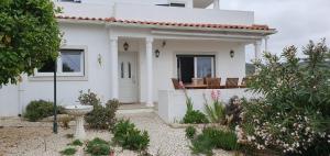 a white house with a garden in front of it at Villa Jopati in Olho Marinho