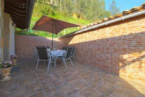 un patio con una mesa y una sombrilla en Casa Yito, en Muñorrodero