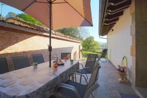 Una mesa y sillas con una sombrilla en un patio. en Casa Yito, en Muñorrodero