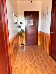 ein Flur mit einer Holztür und einer Topfpflanze in der Unterkunft Golden Sunn Tourist Inn in Puerto Princesa + 1 Foto