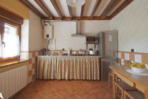 una cocina con una mesa y un refrigerador en Casa Yito, en Muñorrodero