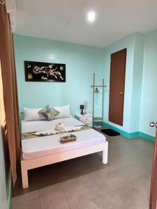 ein Schlafzimmer mit einem großen weißen Bett in einem Zimmer in der Unterkunft Golden Sunn Tourist Inn in Puerto Princesa