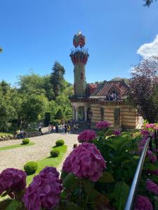 een tuin met paarse bloemen voor een gebouw bij Apartamentos Turísticos La Pontificia in Comillas